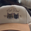 Video close-up of embroidered tabby and black cat portraits on a custom Cat Dad snapback hat